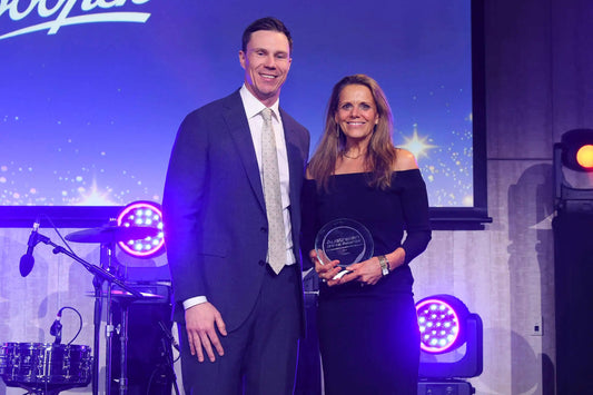 Two people pose on stage with an award